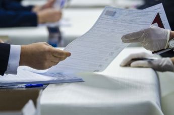 Избиратель получает бюллетень для голосования на выборах депутатов Государственной Думы РФ