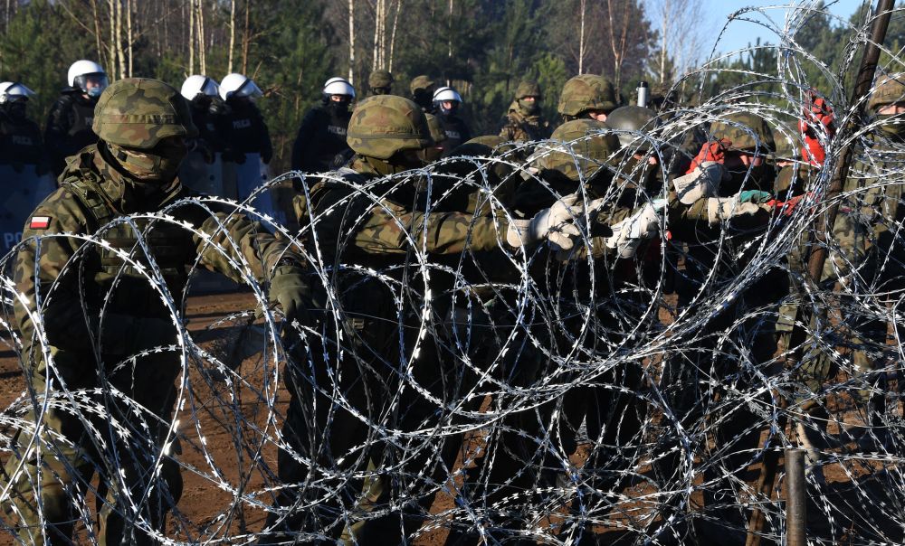 Польские военнослужащие устанавливают забор из колючей проволоки на польско-белорусской границе