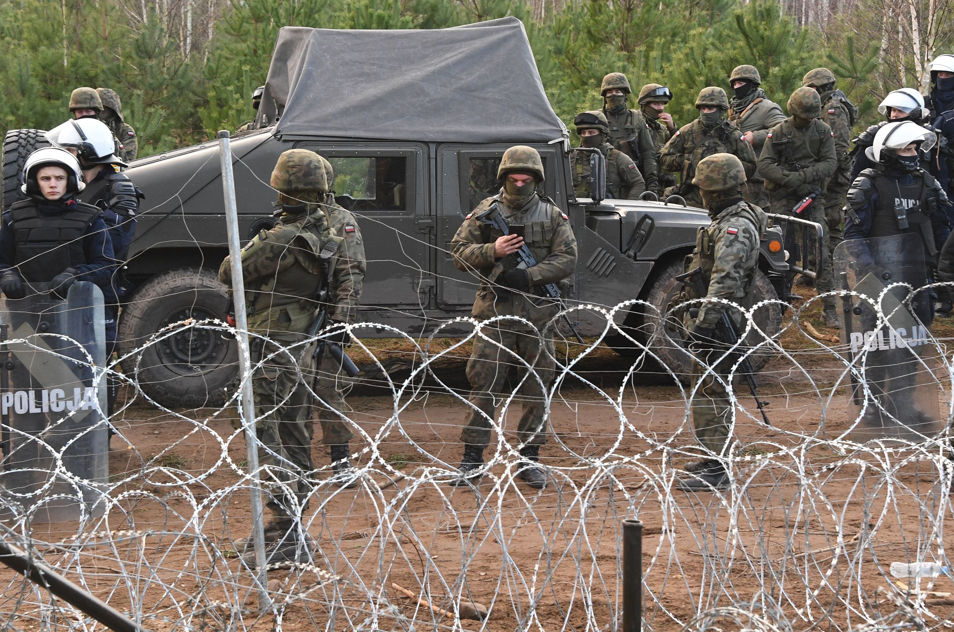 Сотрудники польской полиции и военные у лагеря нелегальных мигрантов на белорусско-польской границе