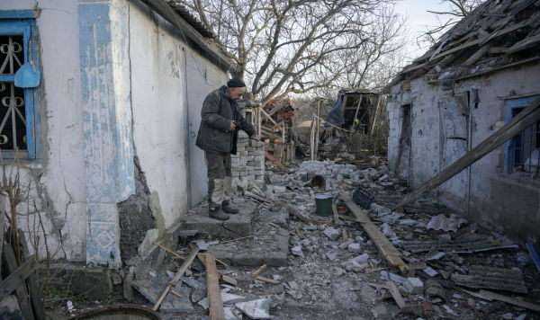 Житель в селе Тарамчук ДНР у здания, поврежденного в результате недавнего обстрела