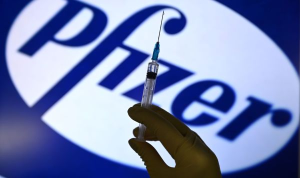 Шприц на фоне логотипа Pfizer