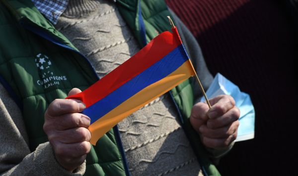 Флажок в руках участника протестного митинга у здания Национального собрания Армении